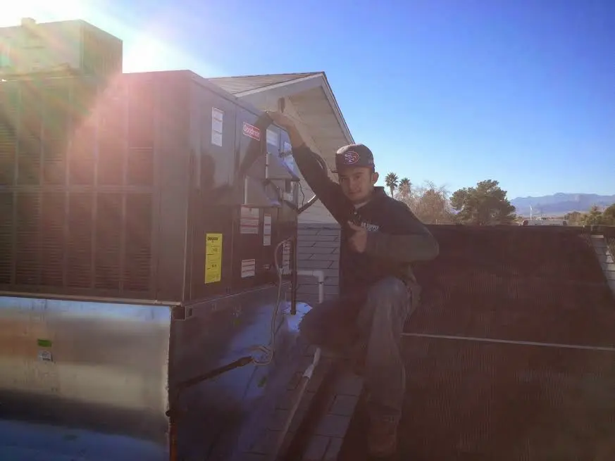 HVAC technician performing HVAC Inspection on a rooftop unit in Roseburg